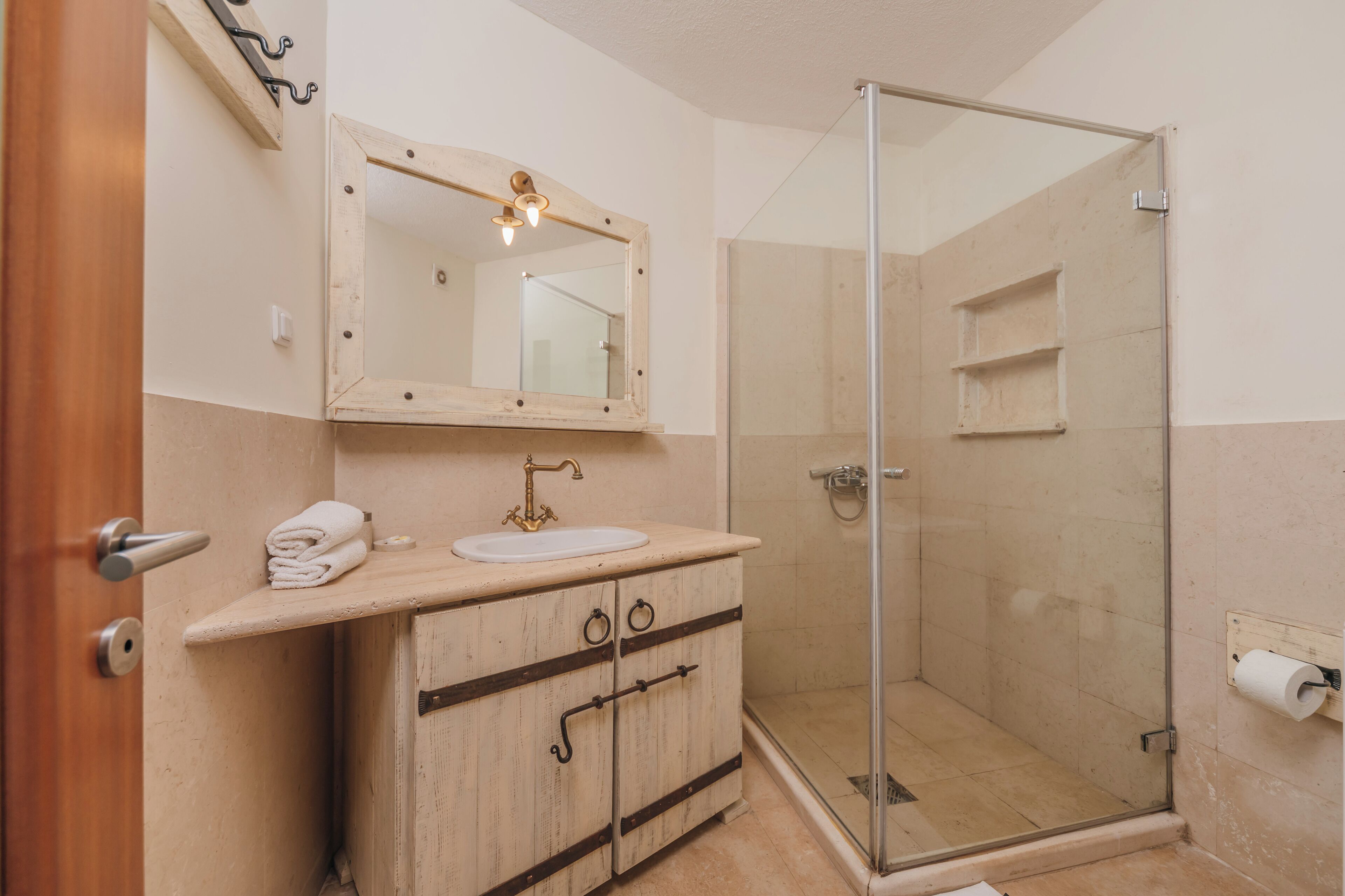 A bathroom with a sink, mirror, and shower.
