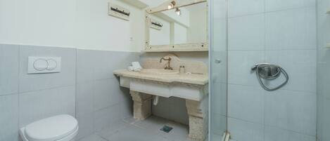 Une salle de bain comprenant des toilettes, un lavabo et un espace douche.