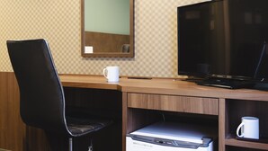 A hotel room with a wooden desk, a black chair, a television, a white mug, and a small appliance. - KOKO HOTEL Shimbashi Onarimon (Tokyo)