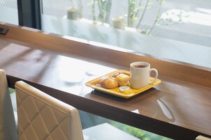 Una mesa de comedor con una bandeja de comida y una taza de café.