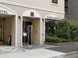 La entrada al Hotel Koko, con un cartel claro, una puerta visible y un pequeño letrero en el exterior.