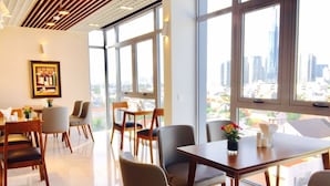 Un espace de restauration moderne, doté de grandes fenêtres, de tables en bois et de chaises confortables.