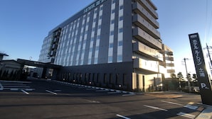 A multi-story hotel with a modern design, featuring a prominent "HOTEL ROUTE" sign on the facade.