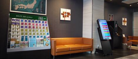 Un vestíbulo moderno de hotel con un gran mapa de Japón, una recepción y una zona de estar.