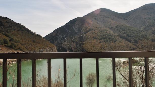 Paisagem montanhosa com um corpo de água em primeiro plano.
