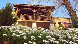 A traditional building with a balcony, surrounded by white flowers. - Le Peyrail (Les Lèves-et-Thoumeyragues)