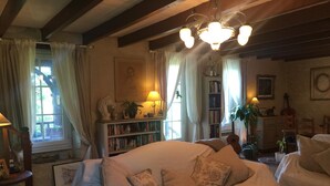 A cozy living room with a large sofa, a wooden coffee table, and a bookshelf filled with books. - Le Peyrail (Les Lèves-et-Thoumeyragues)