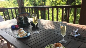 A wooden table with two plates of dessert, two glasses of champagne, and a small figurine. - Le Peyrail (Les Lèves-et-Thoumeyragues)