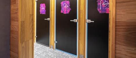 Three wooden doors with black panels and a patterned floor.