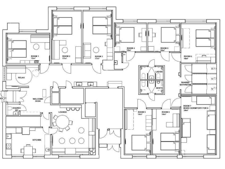 A floor plan of a hotel with 9 rooms, a lounge, kitchen, shared bathroom, and a welcome desk.