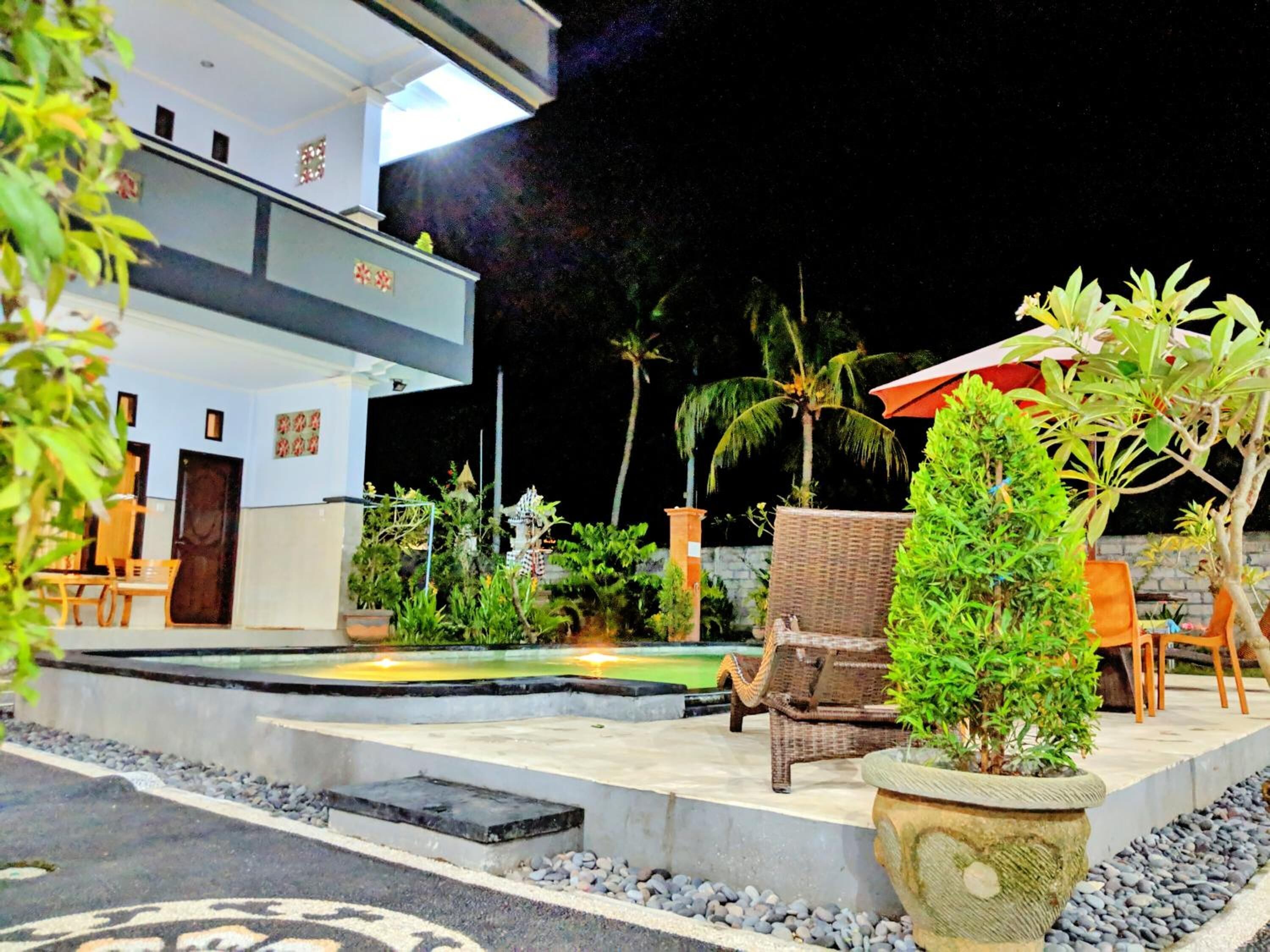 Un hôtel doté d’une piscine, d’un espace extérieur aménagé et de plantes tropicales.