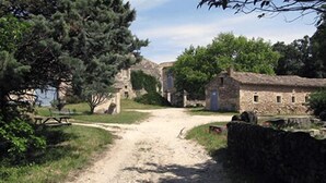 A rural path leading to stone buildings with a picnic table and trees. - Ferme Le Grand Cordy (Grignan)