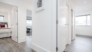 Une chambre d’hôtel moderne avec un lit, une porte blanche et une vue sur la ville.