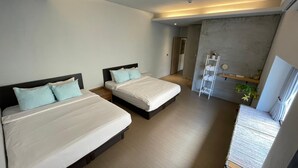 Ein modernes Hotelzimmer mit zwei Betten, einem kleinen Balkon mit Blick und minimalistischem Design.