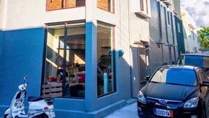 Ein modernes, zweistöckiges Gebäude mit großen Fenstern und einem Roller vor der Tür.