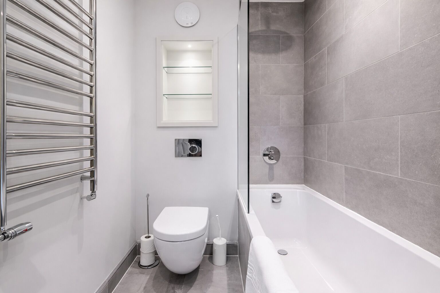 A modern bathroom with a toilet, bidet, and bathtub.