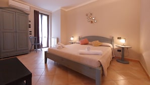 Un dormitorio con cama, lámparas de noche, armario y ventana.