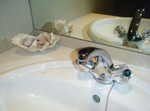 A bathroom sink with a chrome faucet and a mirror above it. - Maison Fontainbleau (Cape Town)