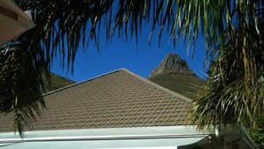 A building with a tiled roof and a white awning. - Maison Fontainbleau (Cape Town)