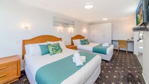 A hotel room with two beds, a desk, a chair, and a TV. - Adrift Apartments (Yamba)