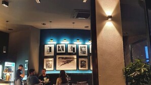 A bar named 'MIMMO' with a modern interior, featuring framed pictures on the wall and a seating area with tables and chairs. - Apartment Aspalathos Centar (Split)