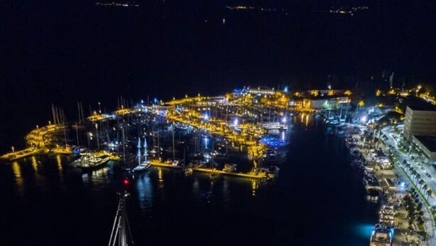 A large yacht docked at a marina with multiple smaller boats, surrounded by well-lit buildings and a clear view of the water. - Apartment Aspalathos Centar (Split)