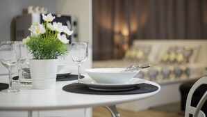 A dining table set with a white bowl, a wine glass, and a potted plant. - Apartment Aspalathos Centar (Split)