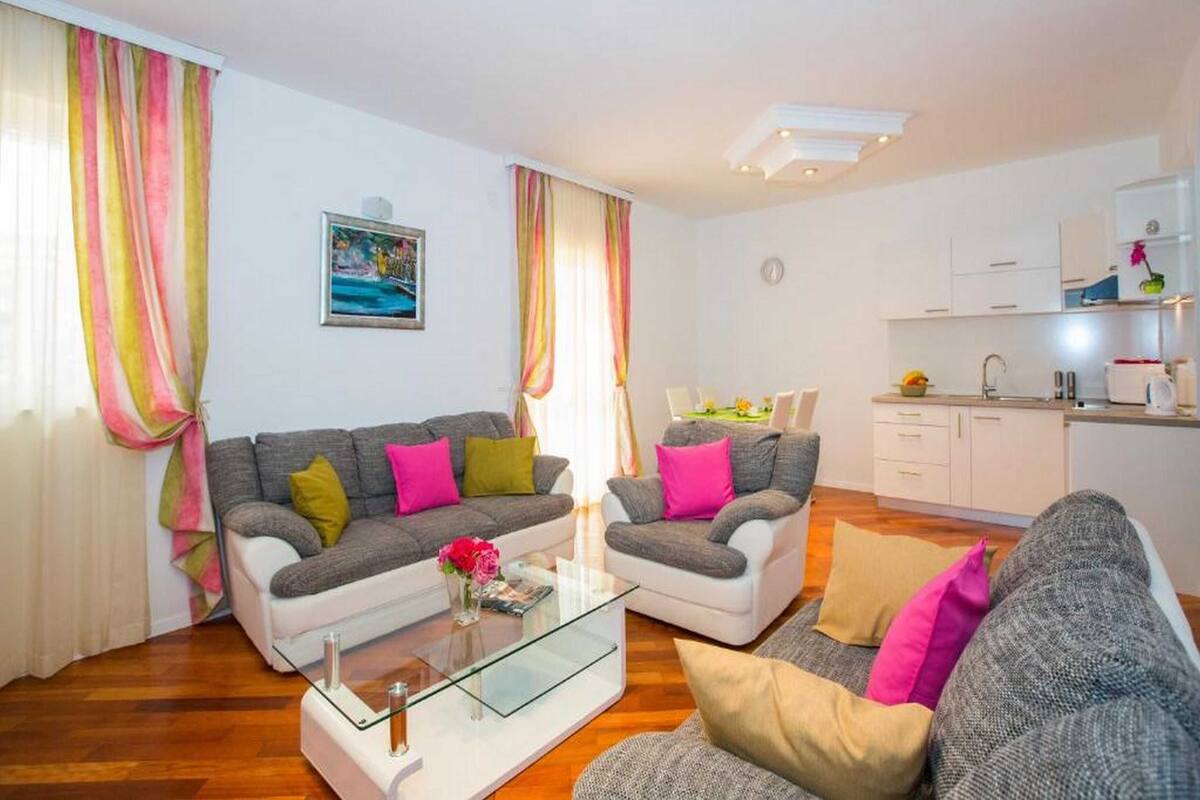Un salon moderne avec deux canapés, une table basse en verre et un coin repas comprenant une table et des chaises.