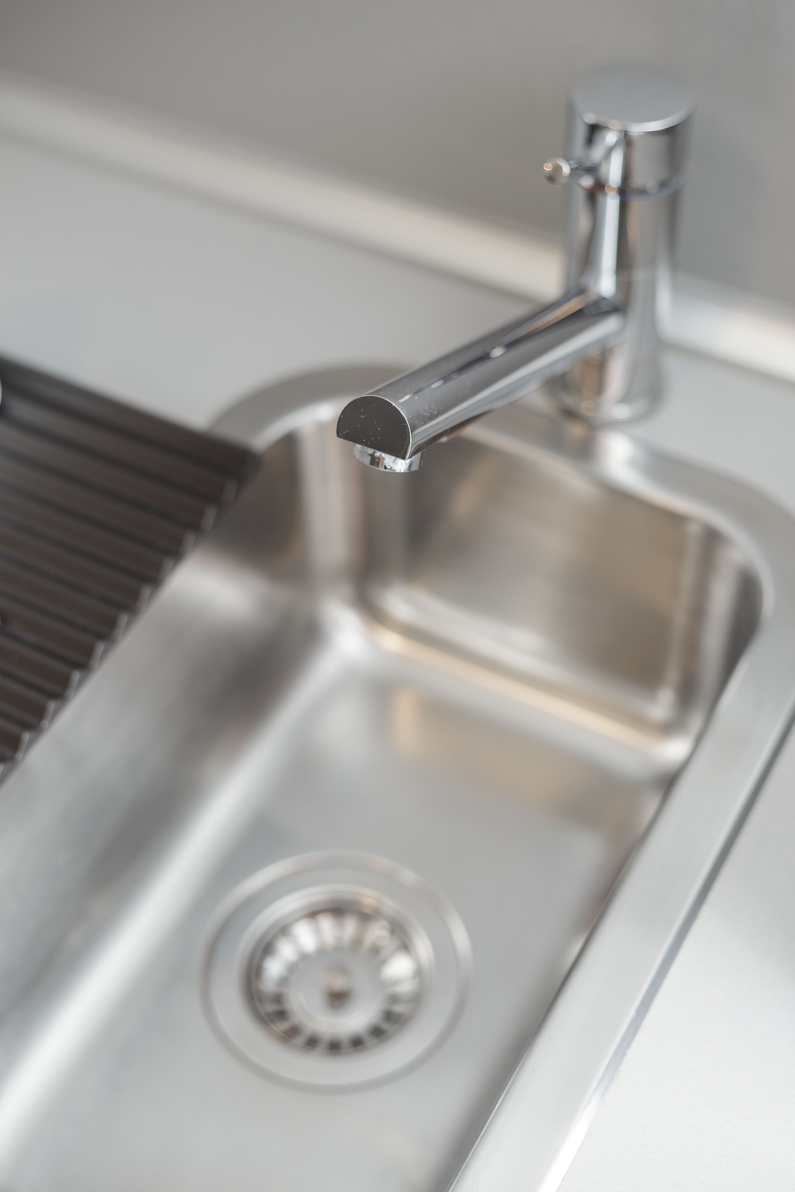 A stainless steel sink with a modern faucet and a drain.
