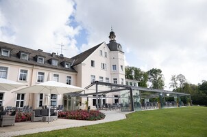 Hotel com área externa, varanda coberta e jardim.