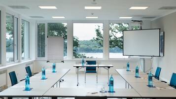 A conference room with a long table, chairs, a projector, and a whiteboard.