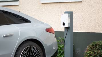 A car parked next to a charging station.