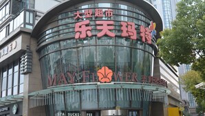 En bygning med en buet glasfacade og skilt med 'May Flower'.