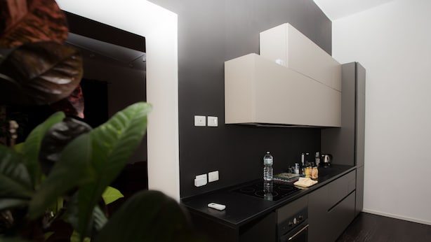 A modern kitchen with black cabinetry, a built-in oven, and a water dispenser on the countertop. - 5 Sirene (Naples)