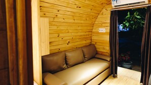 A wooden interior with a sofa and an air conditioning unit. - Mui Ne Alena Bungalow Hotel (Mui Ne)