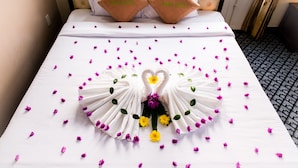 A neatly made bed with a heart-shaped towel arrangement and pillows labeled "Alena Hotel". - Mui Ne Alena Bungalow Hotel (Mui Ne)