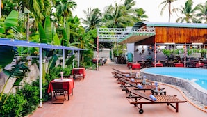 A poolside area with lounge chairs, tables, and a covered seating area. - Mui Ne Alena Bungalow Hotel (Mui Ne)