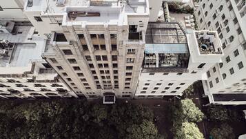 Um edifício alto com vários andares, grandes janelas e varandas.