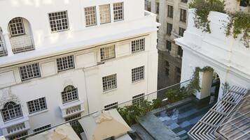 A rooftop terrace with outdoor seating and a view of surrounding buildings.