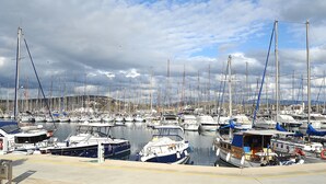 Un puerto deportivo con numerosas embarcaciones amarradas, un cielo despejado y una superficie de agua tranquila.