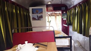 A compact room with a bunk bed, a table with a teapot and cups, and a wall with pictures. - Mahawewa Nature Resort and SPA (Tangalle)