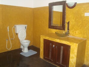 A bathroom with a toilet, sink, and mirror.