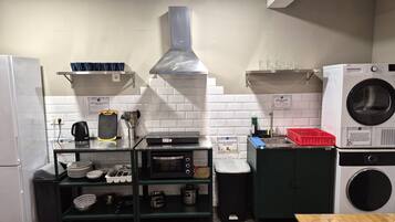 Cocina compacta con microondas, tostadora, pileta y lavadora integrada.