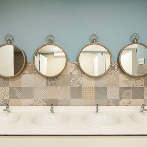 A bathroom with four round mirrors and three sinks. - Balea Hostel (San Sebastián)