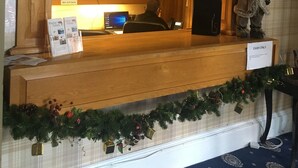 A reception desk with a wooden counter, a computer, and a sign indicating 'CASH ONLY'. - George and Abbotsford Hotel (Melrose)