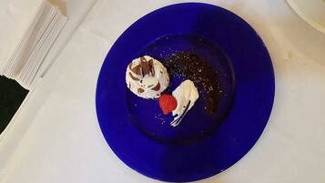 Un postre sobre un plato azul con fondo blanco.