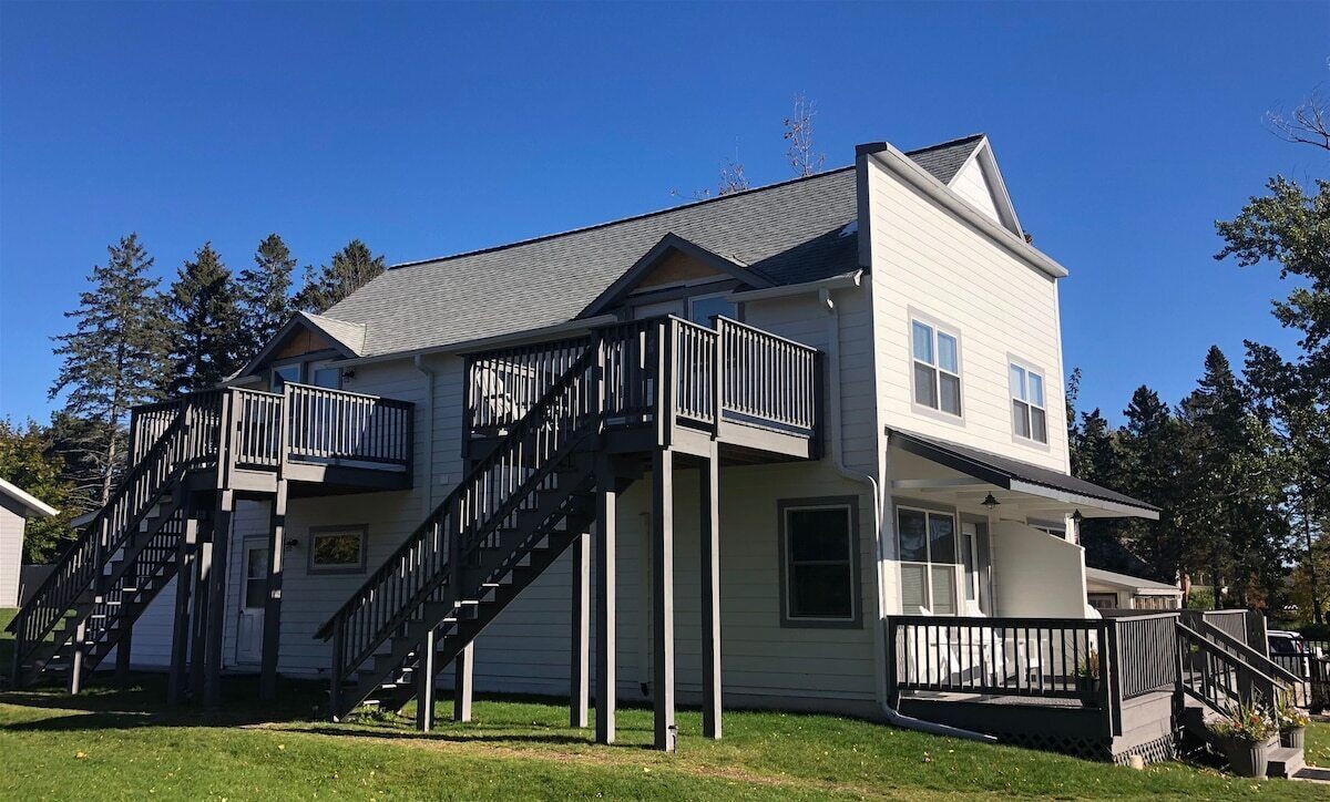 A two-story house with a balcony, a staircase, and a front porch.