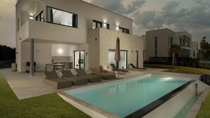 A modern two-story house with a swimming pool, outdoor seating, and a patio area. - Villa Krnica (Marcana)