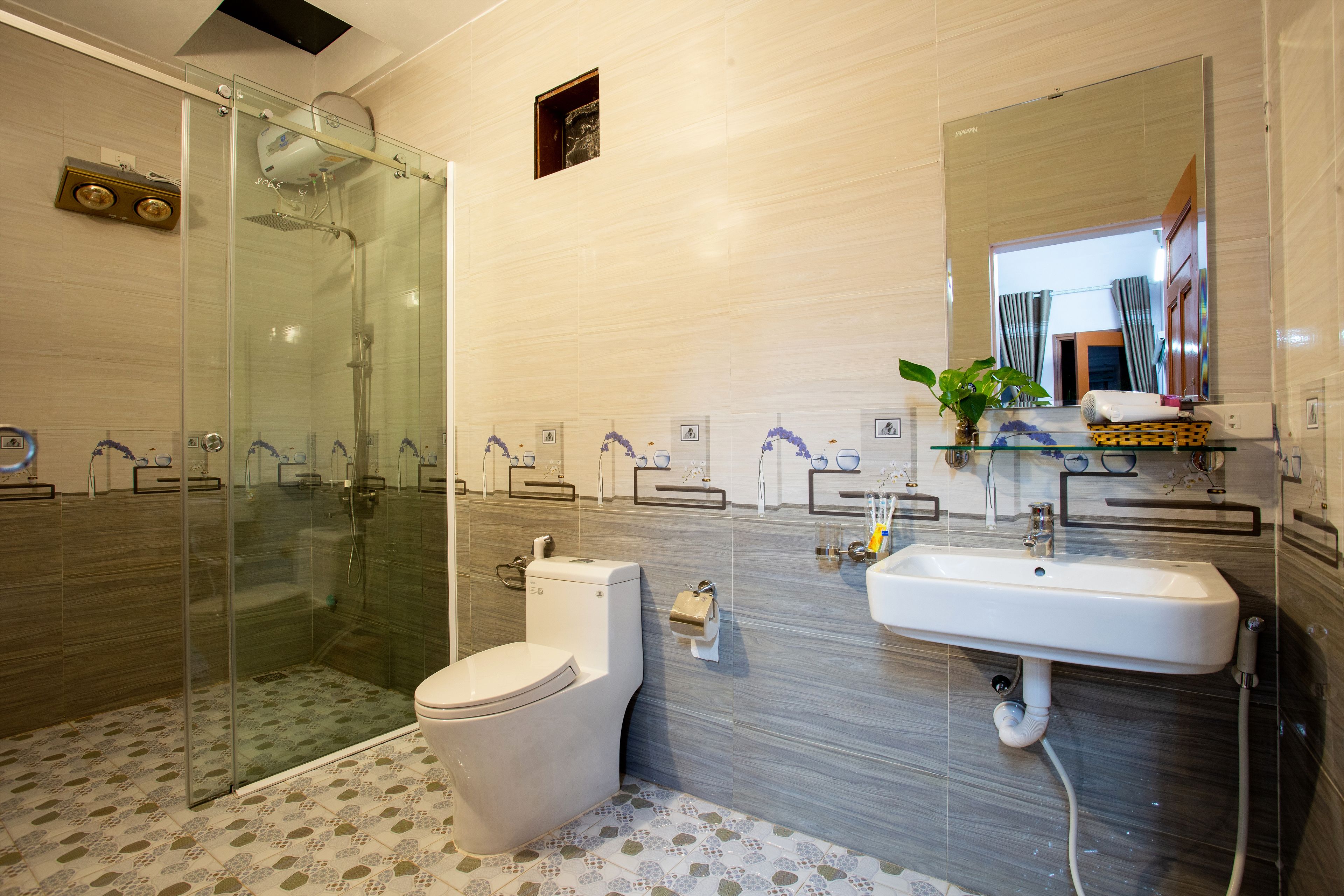 A modern bathroom with a glass shower enclosure, a toilet, and a sink with a mirror above it.