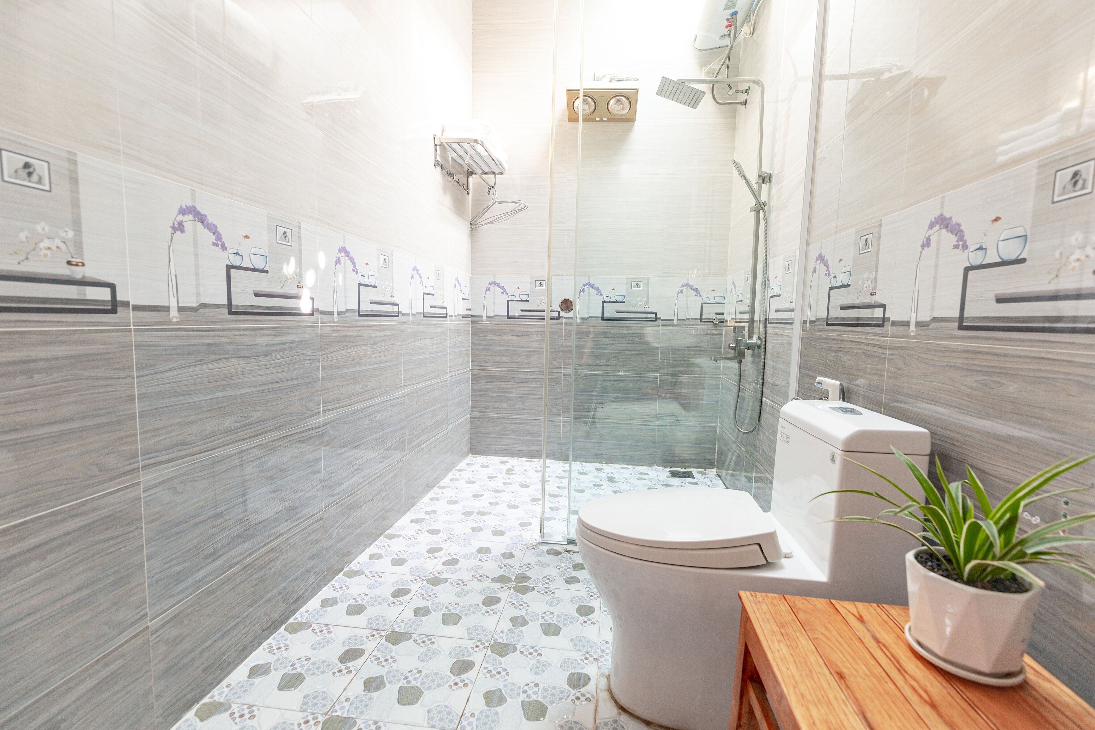 A modern bathroom with a glass shower enclosure, a toilet, and a sink with a mirror.
